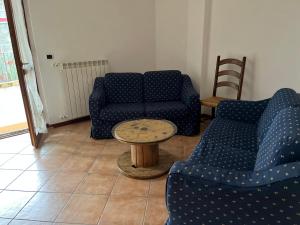 a living room with two blue chairs and a table at La casa della Nonna in Figline Valdarno