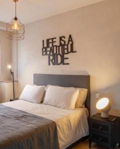 un dormitorio con una cama con un cartel que dice que la vida es un viaje hermoso en Relais Flora Arzo Appartamento superior di vacanza con posteggio, en Mendrisio