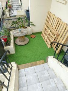 a patio with green grass and a table and chairs at Appart. 3ch - 6mn de la plage de Bonne Grâce in La Seyne-sur-Mer