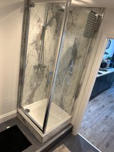 a shower with a glass door in a bathroom at Market View 1 in Hexham