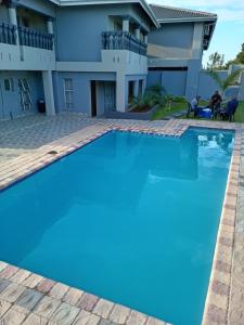a large swimming pool in front of a house at Xaba Guest Lodge in Richards Bay