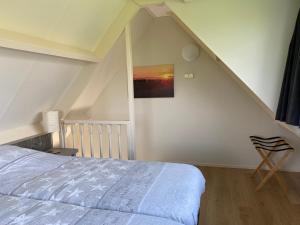 a bedroom with a bed and a painting on the wall at Appartement Zandwerven 23 in Spanbroek