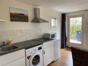 Appartement Zandwerven 23 في Spanbroek: مطبخ مع غسالة ومغسلة