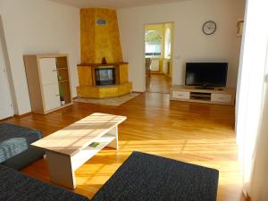 sala de estar con suelo de madera y chimenea en Rekreační chalupa Ivon, 