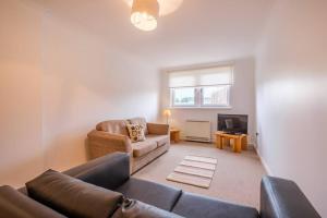 een woonkamer met een bank en een tv bij Station Apartment 1 bed- Lanark in Lanark