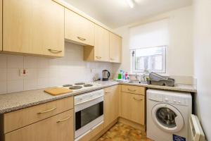 a kitchen with a washing machine and a washer at Station Apartment 1 bed- Lanark in Lanark