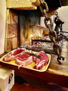 un grill avec de la viande sur une planche à découper dans l'établissement Maison de charme Nature et Rivière au pays basque, à Estérençuby