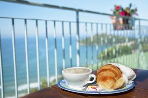 a cup of coffee and a croissant on a table at Hotel Arenauta in Gaeta