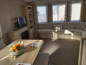 a living room with a bowl of fruit on a table at Caravan By The Sea in Elgin