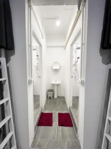 a bathroom with a toilet and a red rug at Magic Hostel in Phi Phi Don
