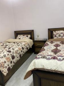 - 2 lits installés l'un à côté de l'autre dans une chambre dans l'établissement Jerash air apartment, à Jerash