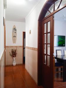 a hallway with a door and a vase on the wall at Chalas place in Nazaré