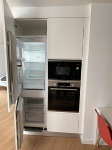 a kitchen with an open refrigerator and a microwave at Living PDL 2 in Ponta Delgada