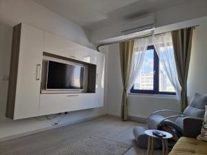 ein Wohnzimmer mit einem TV und einem Sofa in der Unterkunft Apart Confort in Bacău