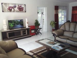 a living room with two couches and a tv at Protea Avenue Margate in Margate