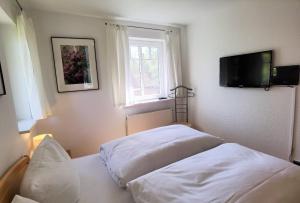 a bedroom with two beds and a flat screen tv at Ferienwohnung Seestern in Bad Saarow