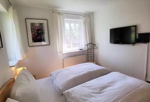 1 Schlafzimmer mit 2 Betten und einem Flachbild-TV in der Unterkunft Ferienwohnung Seestern in Bad Saarow