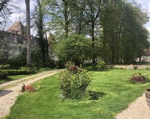a garden with green grass and flowers and a house at La Ferme du Château in Beire-le-Châtel
