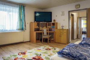 um quarto com uma cama e uma secretária com uma televisão em Ferienwohnungen Hubner 1 am Flattachberg em Flattach