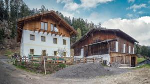 a house and a barn with a pile of dirt at Ferienwohnungen Hubner 1 am Flattachberg in Flattach
