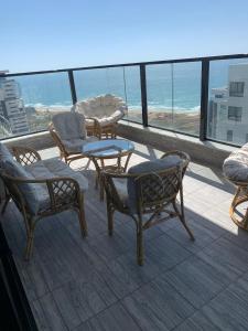 balcón con mesa, sillas y vistas al océano en panoramic apartment EdenTower, en Bat Yam