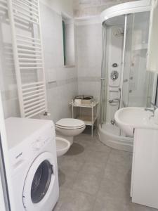 een witte badkamer met een wasmachine bij Trullo Le Tre Sorelle in Cisternino