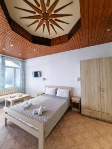 1 dormitorio con 1 cama grande y techo de madera en Crysalis Studios, en Kalamaki