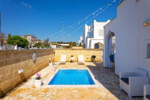 - une piscine dans une cour avec une maison dans l'établissement Villa Teresa, à Torre Lapillo