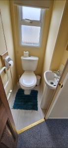 uma casa de banho com um WC, um lavatório e uma janela em Oor wee hoose em Leswalt
