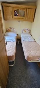 two beds in a small room with at Oor wee hoose in Leswalt