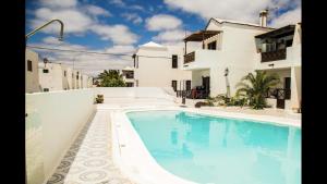 a swimming pool in front of a house at OasisstudioLanzarote in Puerto del Carmen
