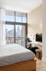 a bedroom with a bed and a large window at UNTITLED 3 Freeman Alley in New York