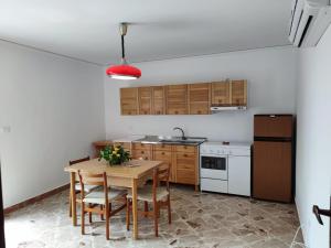 cocina con mesa, sillas y fregadero en Villa Ginestra, en Santa Ninfa