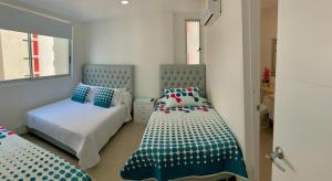 um quarto com 2 camas em azul e branco em 2P1-AL3 APARTAMENTO DE 2 ALCOBAS FRENTE AL MAR CON AIRE ACONDICIONADO Y WIFI em Cartagena das Índias
