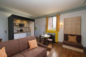 a living room with a couch and a table at Villa Forestière Studio Le Sophora in Quincy-Voisins