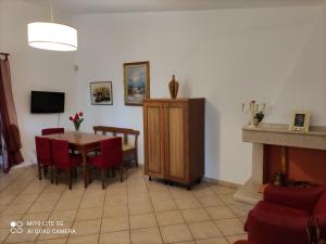 ein Esszimmer mit einem Tisch und Stühlen sowie einem TV in der Unterkunft Villetta Vacanza in Carovigno