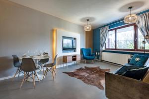 a living room with a table and blue chairs at Premium Apartment for Jewish Quarter & Old Town plus Pool in Kraków