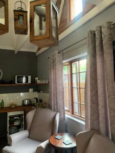 a living room with a couch and a window at Greenwood Lea Cottage - luxury, romantic cottage in Hilton