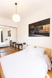 um quarto branco com uma cama e uma sala de estar em Proche Panier, appartement cosy vue mer em Marselha
