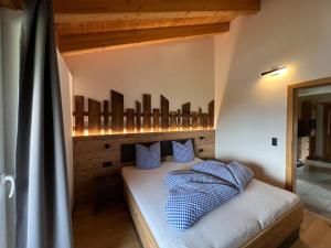 ein Schlafzimmer mit einem Bett mit blauen Kissen darauf in der Unterkunft Studlerhof in Oberperfuss