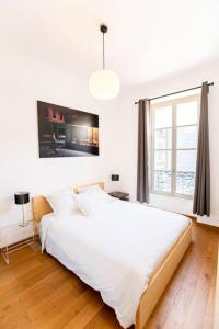 - une chambre avec un grand lit blanc et une fenêtre dans l'établissement Proche Panier, appartement cosy vue mer, à Marseille