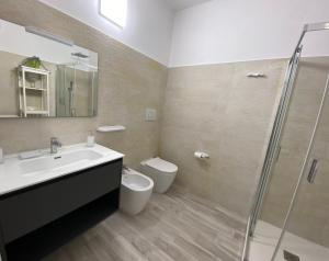 a bathroom with a sink and a toilet and a shower at Torre dei Corsari APPARTAMENTO CON GIARDINO VISTA MARE in Torre Dei Corsari