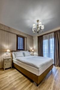 um quarto com uma cama grande e um lustre em MONTANA LAKE VIEW em Ioannina