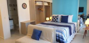 a bedroom with two beds with blue and white pillows at Edf Time Ponta Verde, Studio 523 in Maceió