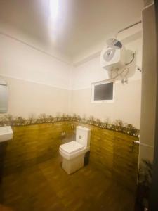 een badkamer met een toilet en een camera aan de muur bij White Eco Villa in Kandy