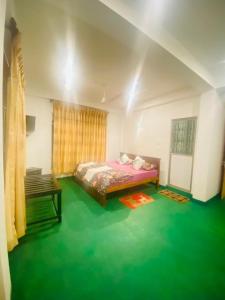 a bedroom with a bed and a green floor at White Eco Villa in Kandy