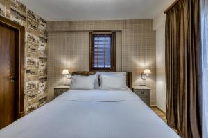 een slaapkamer met een groot bed met witte lakens bij MONTANA LAKE VIEW in Ioannina