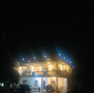 a lit up house with a balcony at night at White Eco Villa in Kandy