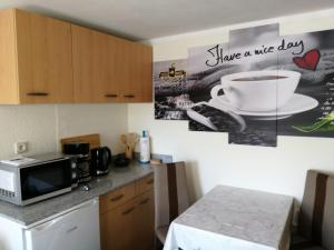 a kitchen with a microwave and a sign that says have a nice day at Ferienwohnung auf Rügen in Putbus +5 photos