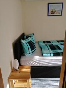 a small bedroom with a bed and a night stand at Ferienwohnung auf Rügen in Putbus +5 photos